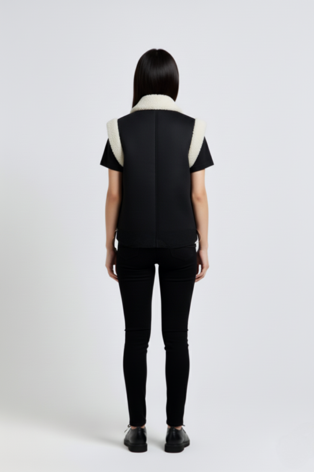 Rear view of female model wearing Maverick Elle shearling vest showing structured shoulder fit and straight back styling. Maverick Jacket.