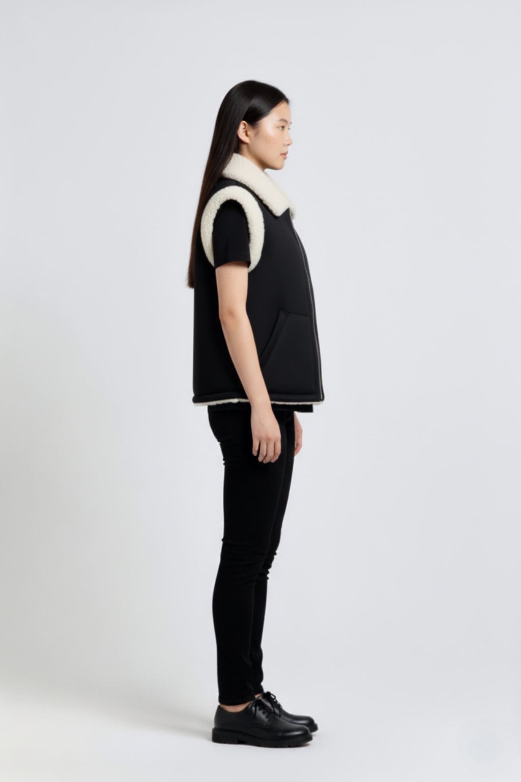 Side profile of Maverick Elle shearling vest showing shearling-trimmed armholes and boxy hip-length silhouette. Maverick Jacket.