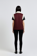 Rear view of female model wearing Maverick Elle shearling vest showing structured shoulder fit and straight back styling. Maverick Jacket.