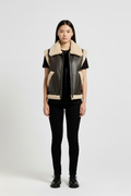 Female model wearing Maverick Clara shearling vest, relaxed fit, styled with black skinny trousers and black leather derby shoes. Maverick Jacket.