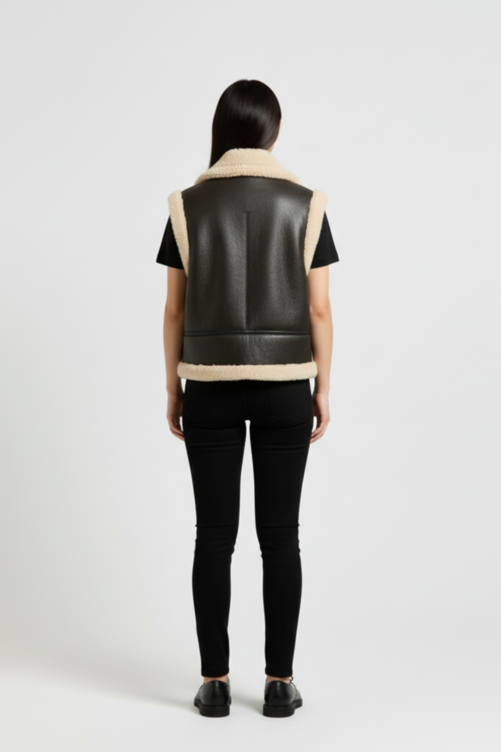 Rear view of female model wearing Maverick Clara shearling vest showing structured shoulder fit and straight hem styling. Maverick Jacket.