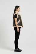 Side profile of Maverick Clara shearling vest showing shearling-trimmed armholes and boxy hip-length silhouette. Maverick Jacket.