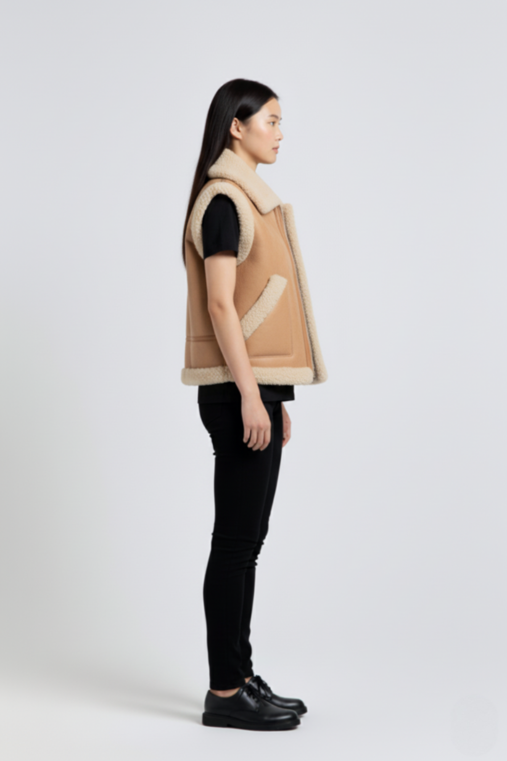 Side profile of Maverick Clara leather vest showing shearling-trimmed armholes and boxy hip-length silhouette. Maverick Jacket.