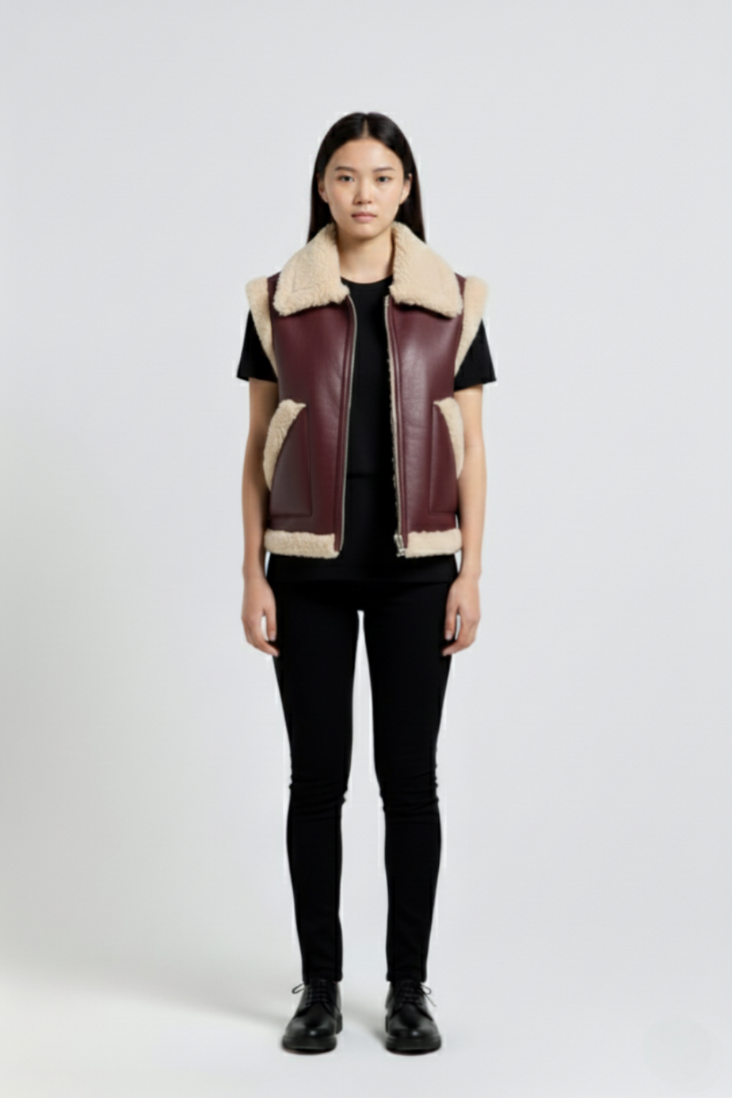 Female model wearing Maverick Clara shearling vest, relaxed fit, styled with black skinny trousers and black leather derby shoes. Maverick Jacket.