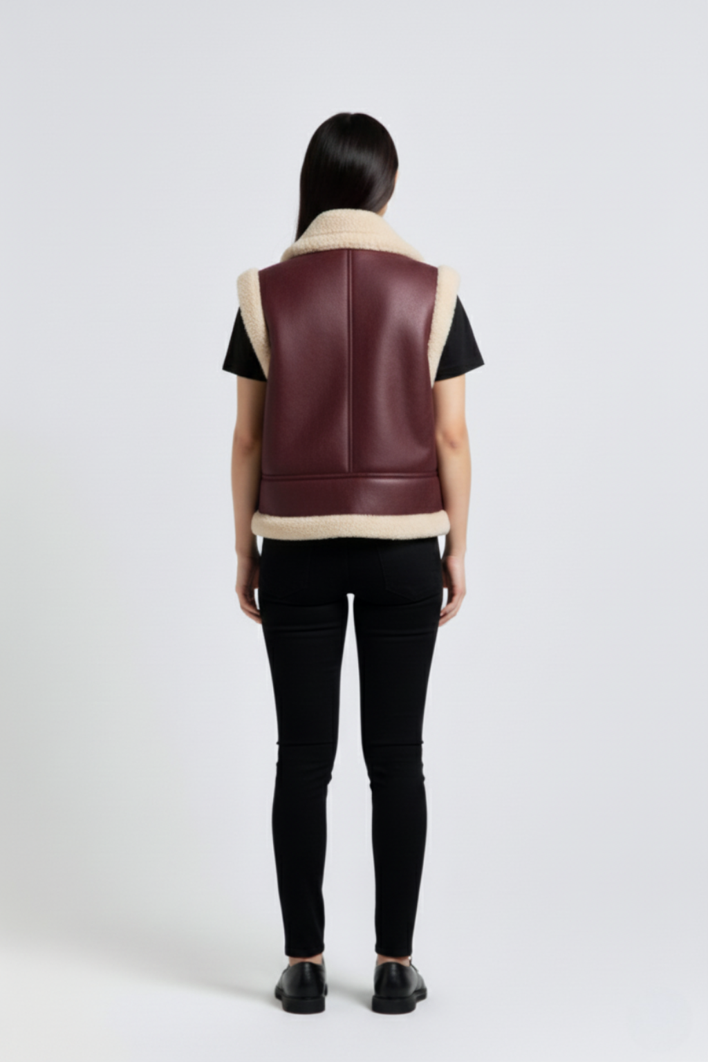 Rear view of female model wearing Maverick Clara shearling vest showing wide shoulder fit and straight back styling. Maverick Jacket.