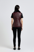 Rear view of female model wearing Maverick Isabelle quilted vest showing tailored waist fit and diamond stitched back styling. Maverick Jacket.