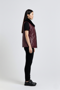 Side profile of Maverick Isabelle quilted vest showing sleeveless armhole cut and slim hip-length silhouette. Maverick Jacket.