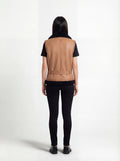 Rear view of female model wearing Maverick Valentina shearling vest showing structured back fit and belted hem styling. Maverick Jacket.