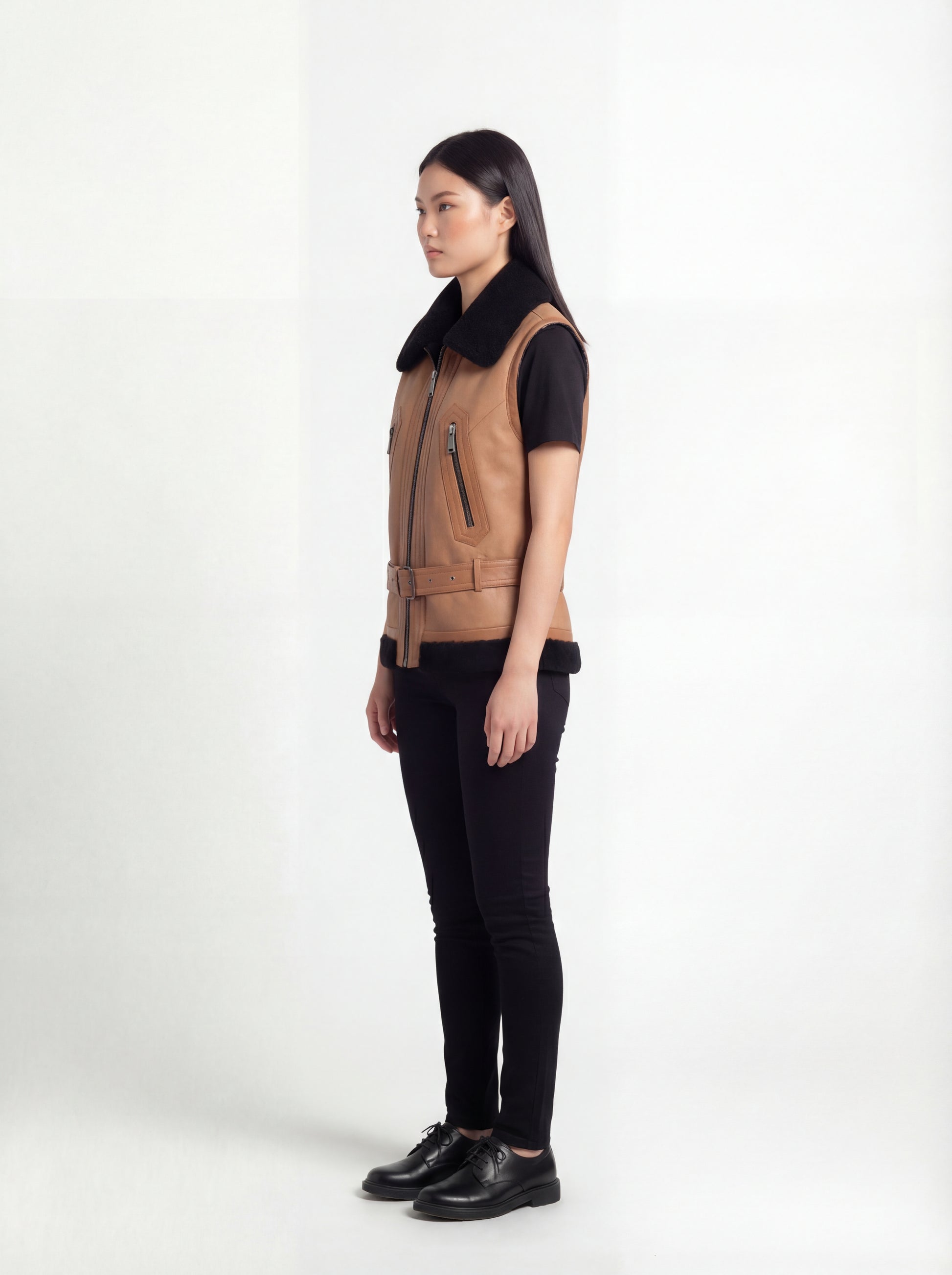 Side profile of Maverick Valentina shearling vest showing sleeveless structure and fitted waist-length silhouette. Maverick Jacket.