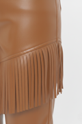 Macro shot of smooth tan leather texture and precision-cut fringe detailing on pants. The Stevie by Maverick Jacket.