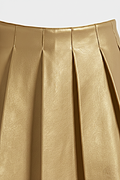 Macro shot of smooth gold leather grain and structured knife pleat detailing on skirt. The Poppy by Maverick Jacket.