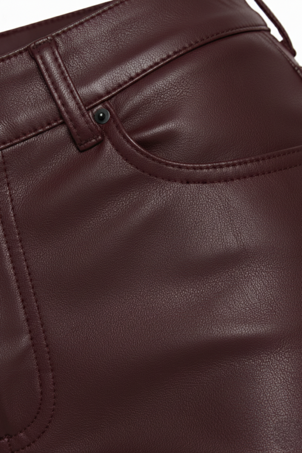 Macro shot of burgundy leather grain and pocket stitching detail on flare pants. The Bianca by Maverick Jacket.
