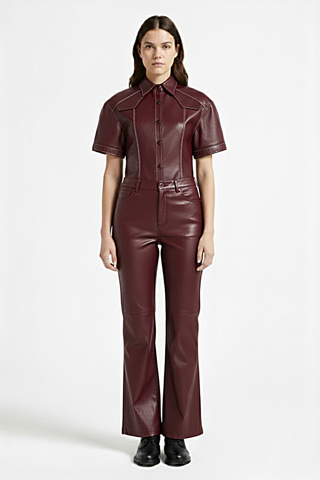 Female model wearing Maverick Bianca burgundy leather flare pants, high-waisted fit, styled with matching green leather short-sleeve shirt and burgundy leather boots. Maverick Jacket.