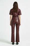 Rear view of female model wearing Maverick Bianca leather flare pants showing fitted seat and bootcut leg styling. Maverick Jacket.