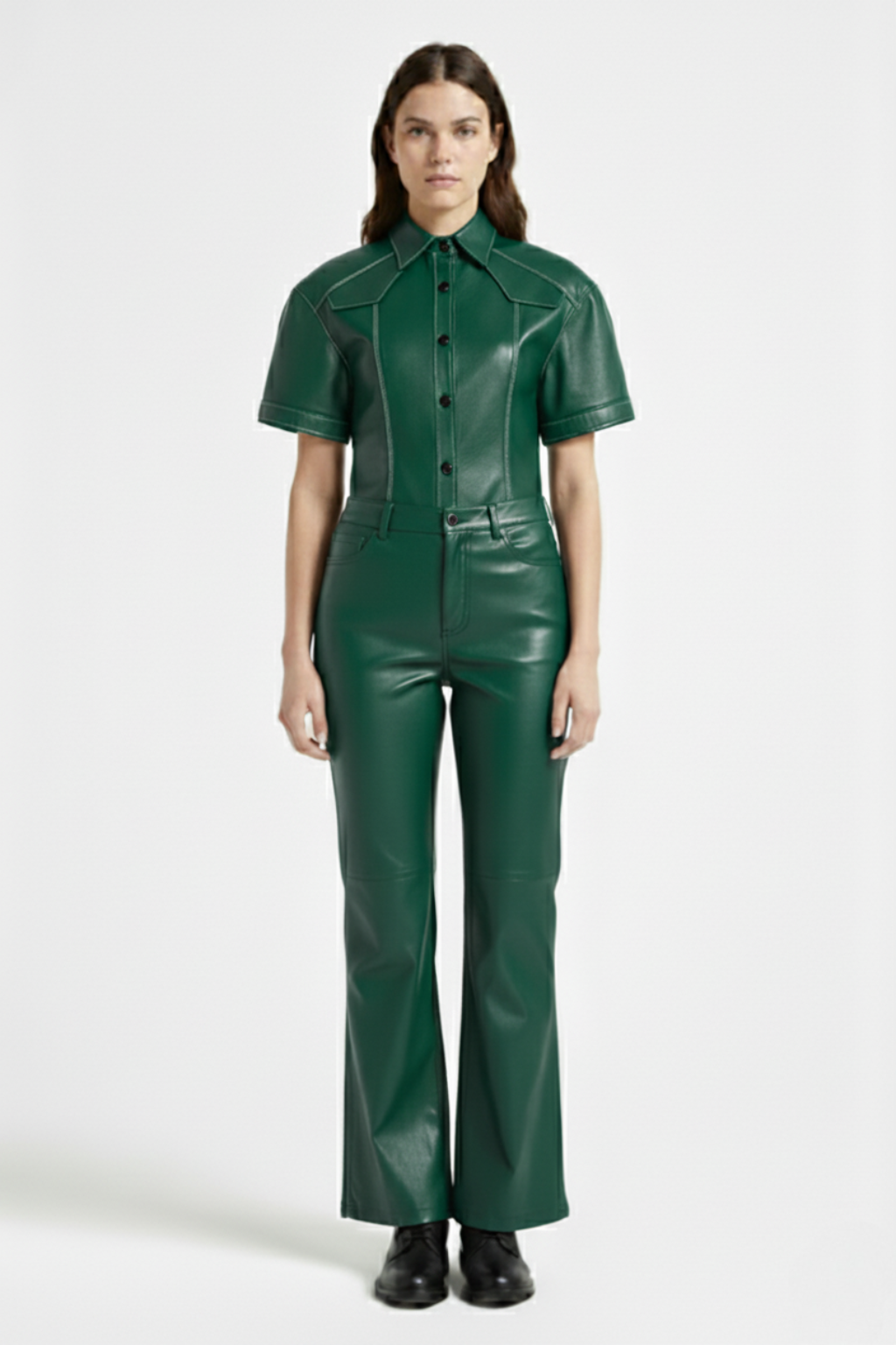 Female model wearing Maverick Bianca green leather flare pants, high-waisted fit, styled with matching green leather short-sleeve shirt and black leather boots. Maverick Jacket.