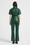 Rear view of female model wearing Maverick Bianca leather flare pants showing fitted seat and bootcut leg styling. Maverick Jacket.