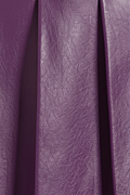 Macro shot of smooth purple leather grain and structured knife pleat detailing on skirt. The Poppy by Maverick Jacket.