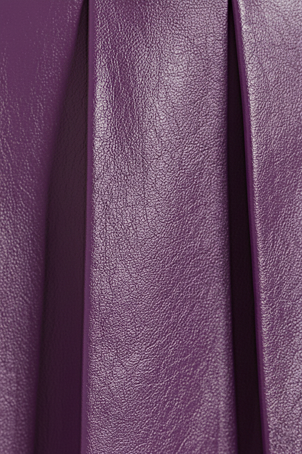 Macro shot of smooth purple leather grain and structured knife pleat detailing on skirt. The Poppy by Maverick Jacket.