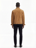 A man viewed from behind wearing a tan suede jacket, black pants, and black shoes against a plain white background.