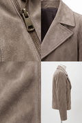 Close-up of the Maverick Gage taupe suede moto jacket, highlighting its asymmetrical gunmetal front zipper.