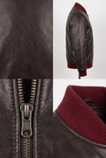 A Maverick Holden brown leather bomber jacket with a deep burgundy ribbed knit collar, shown in a multi-panel layout featuring a full side profile on a mannequin, a close-up of the leather texture, a close-up of the metal zipper pull, and a close-up of the collar.