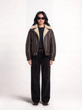 Front view of model in Maverick Taryn B-3 shearling bomber jacket, black tee, skinny black jeans and derby shoes; boxy fit.