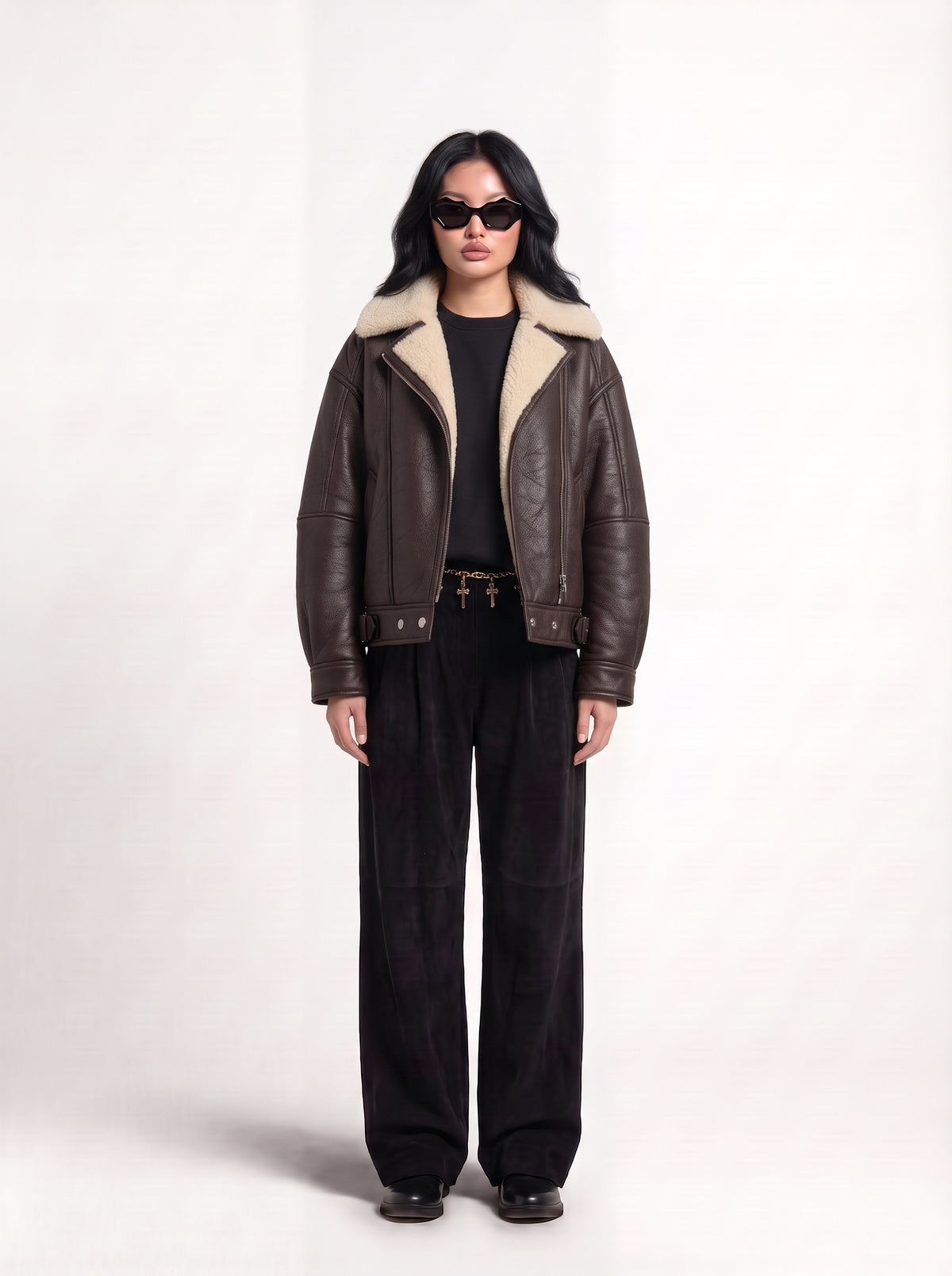 Front view of model in Maverick Taryn B-3 shearling bomber jacket, black tee, skinny black jeans and derby shoes; boxy fit.