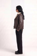 Side view of model in Maverick Taryn B-3 shearling bomber jacket, black tee, skinny black jeans and derby shoes; boxy fit.